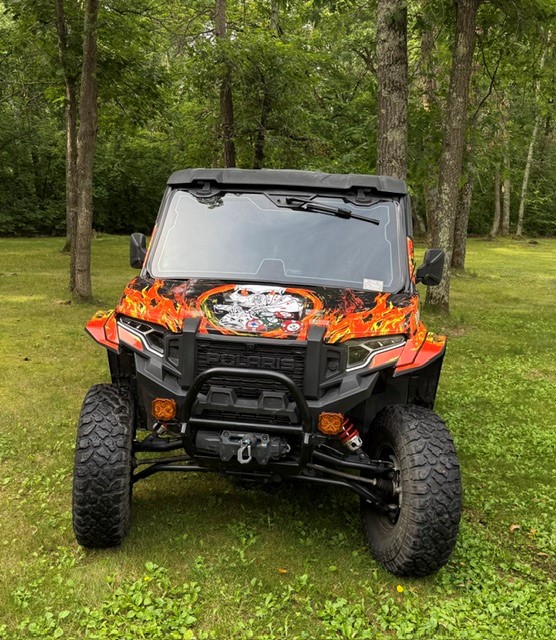 A Polaris Xpedition 2 door side-by-side with a custom design vinyl wrap and silver flake laminate